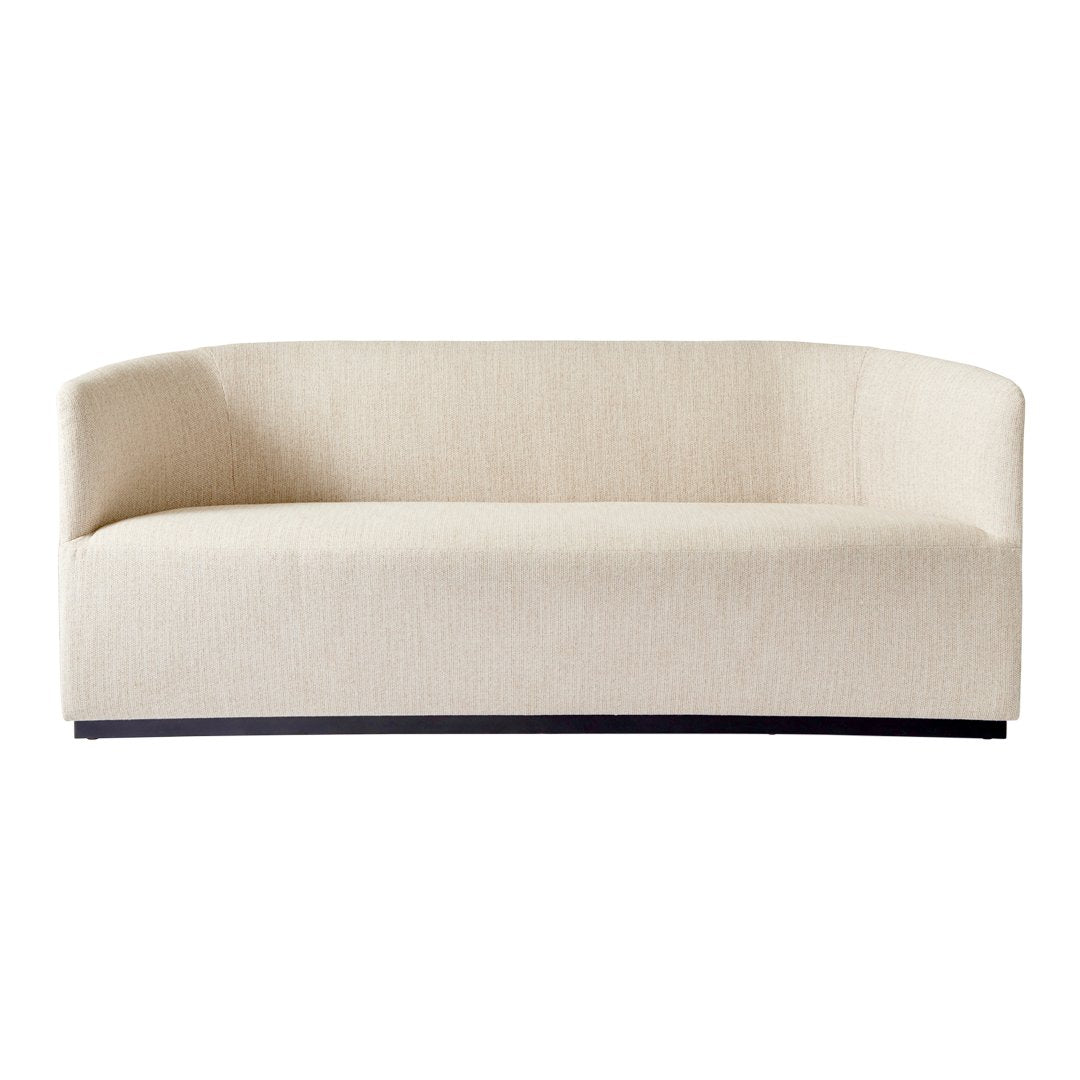 Beige curved sofa with a subtle textured pattern and sleek black base, perfect for modern decor.