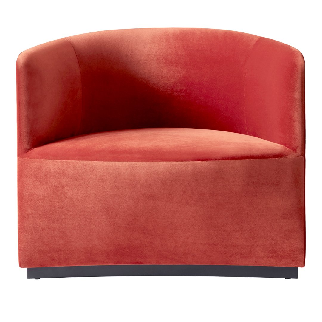 Coral velvet accent chair with smooth texture and rounded design, perfect for modern decor.