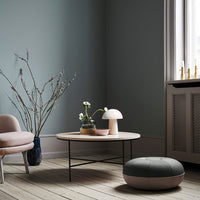 Soft blue-green wall, minimalist light wood flooring, pastel pink accents, and subtle gray patterns in soft furnishings.