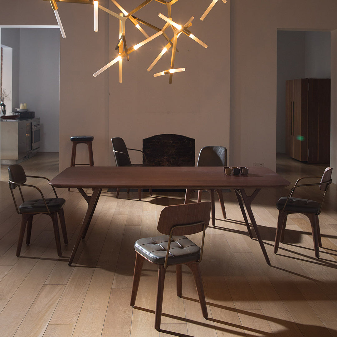 Modern brown dining table with sleek lines, surrounded by neutral-toned chairs in a stylish, minimalistic setting.