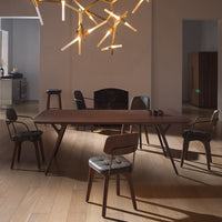 Modern brown dining table with sleek lines, surrounded by neutral-toned chairs in a stylish, minimalistic setting.