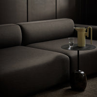 Modern dark gray sofa with smooth fabric. Stylish minimalist side table in black and beige accents.