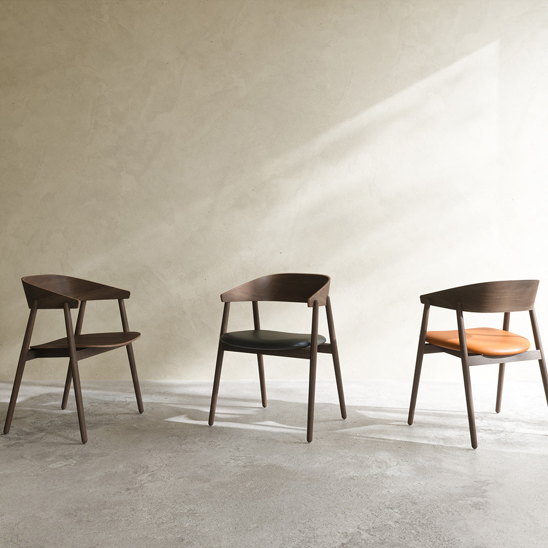 Set of three modern wooden chairs featuring dark walnut tones with black and orange cushions.