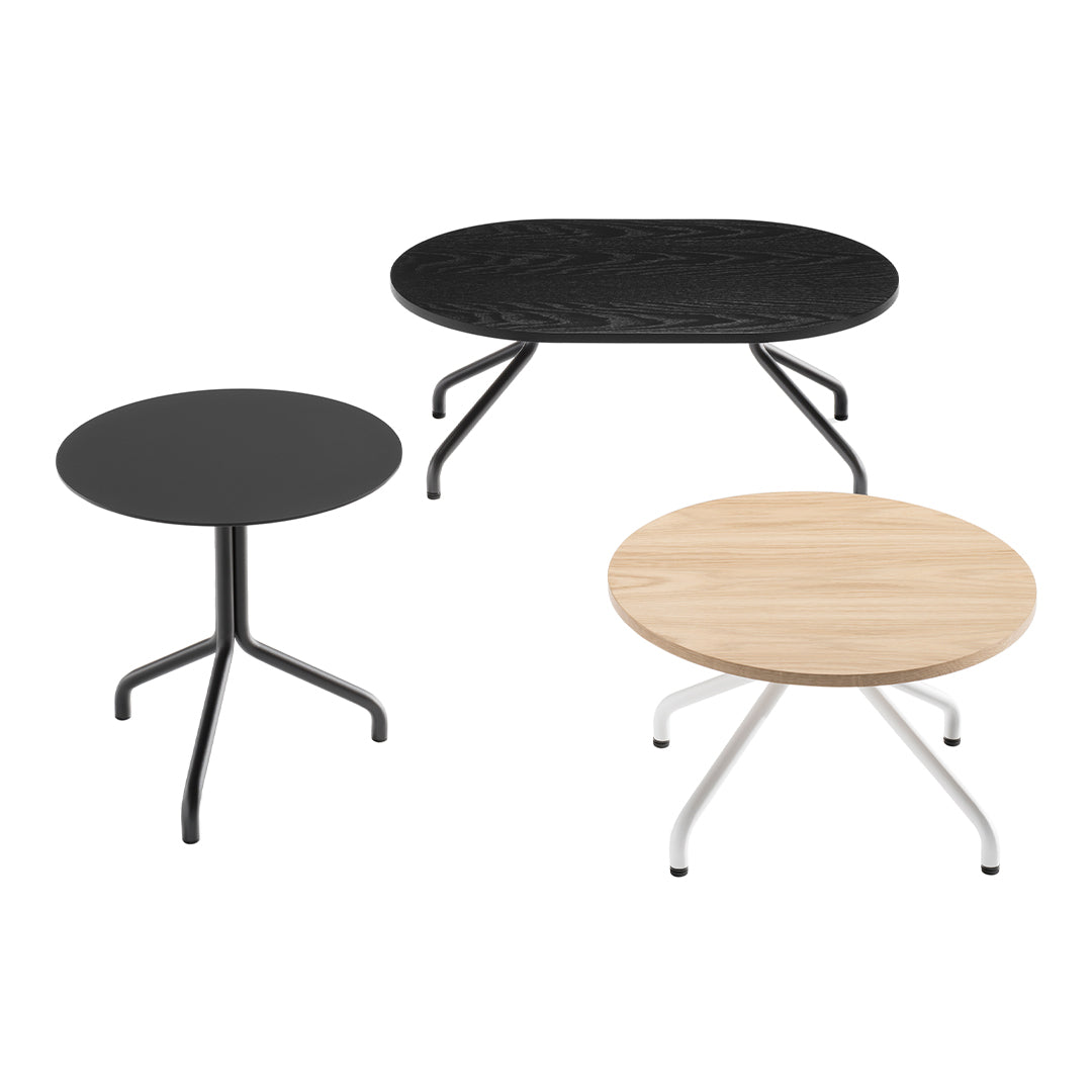 Three modern coffee tables: one round black, one oval black with textured finish, and one light wood finish with white legs.