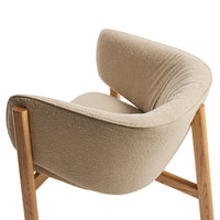 Beige plush chair with a curved back and natural wood legs, showcasing a soft texture and minimalist design.