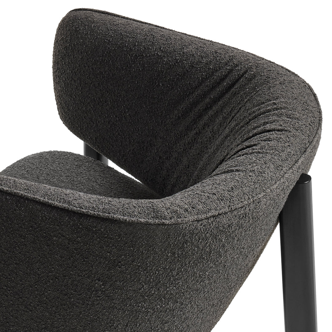 Dark grey textured fabric with a smooth, curved design and sleek black legs.