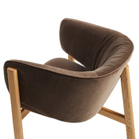 Brown velvet upholstered chair with natural wooden legs, featuring a smooth, curved design. Perfect for modern decor.
