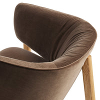 Soft brown velvet chair with a curved backrest and light wooden legs, perfect for adding warmth to any space.