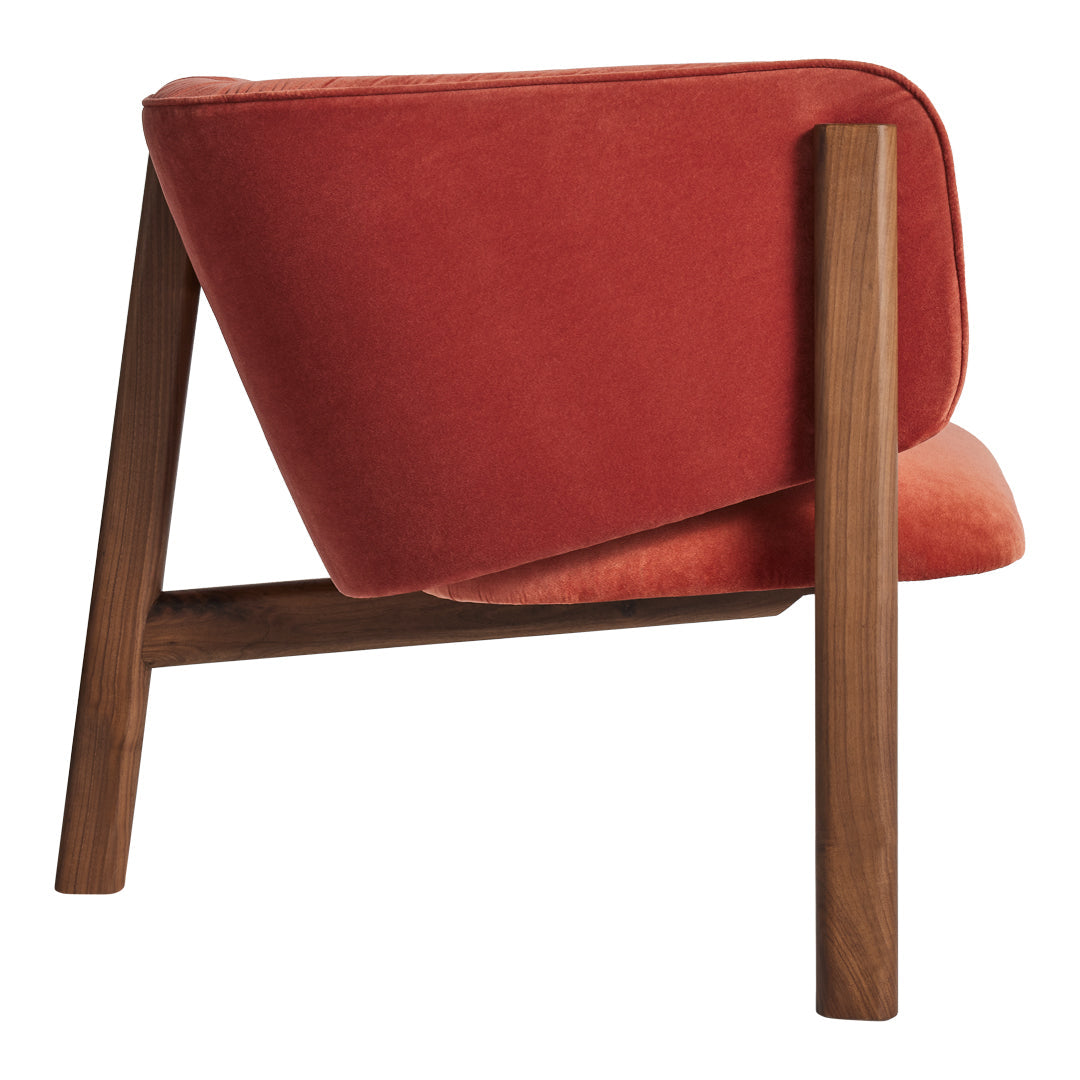 Rust-orange velvet chair with a minimalist design and warm wood legs, showcasing a modern, stylish aesthetic.