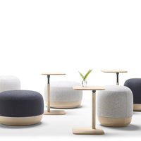 Set of modern poufs in gray, white, and navy with a minimalist wooden table, featuring soft textures and rounded shapes.