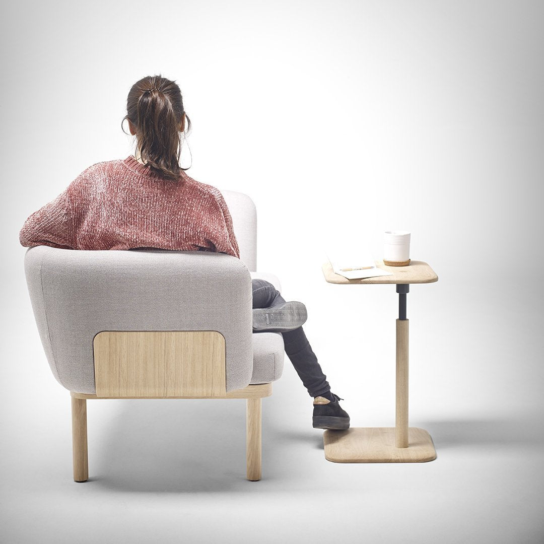 Light gray armchair with wooden accents, paired with a minimalist wooden side table; cozy and modern design elements.