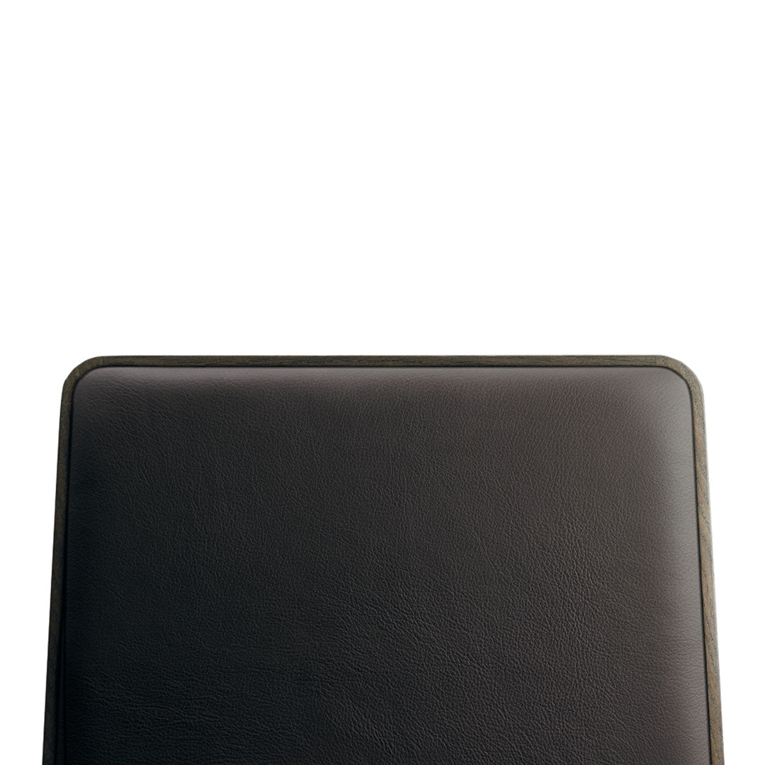 Black square cushion with a smooth texture and rounded edges, featuring subtle stitching detail along the trim.