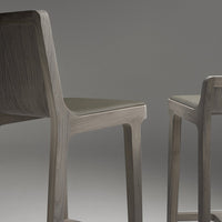 Modern wooden chairs in a sleek gray finish with a minimalist design. Ideal for contemporary decor.