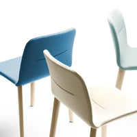 Three stylish chairs in soft blue, light blue, and cream colors with wooden legs and minimalist design.