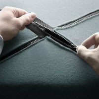 Teal fabric with a smooth texture and silver zipper, revealing a contrasting inner layer.