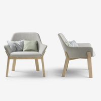 Gray fabric armchair with light wood legs, featuring subtle pastel throw pillows in green and gray.