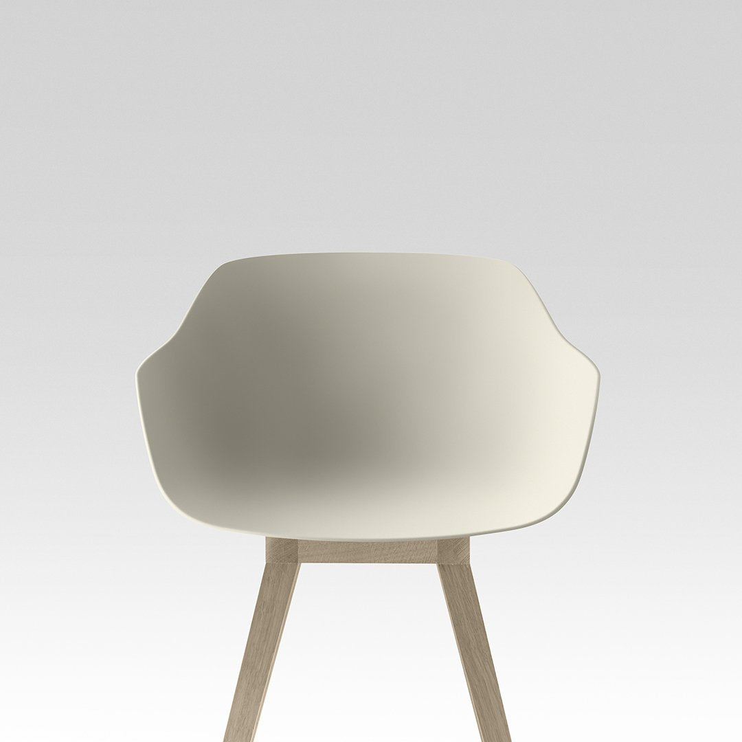 Minimalist cream chair with smooth, curved design and light wooden legs against a soft gray background.