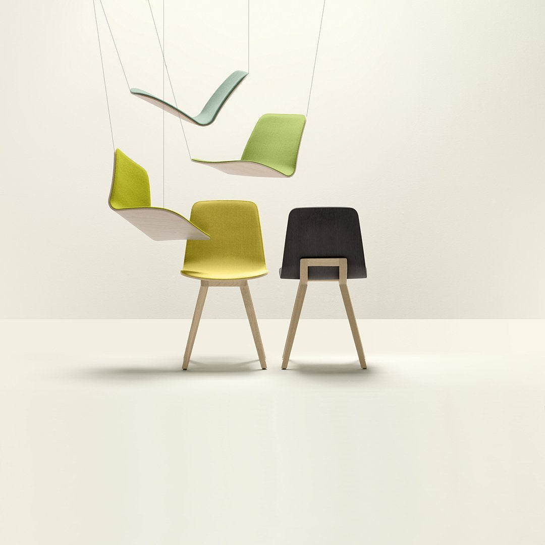 "Modern chairs in vibrant green and yellow, with sleek black accents and wooden legs against a minimalist backdrop."