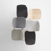 Aerial view of six chairs in textured fabrics: black, gray, light gray, and natural wood tones.