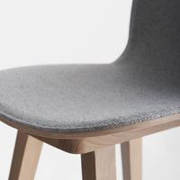 Gray upholstered chair seat with a smooth texture and natural wood legs. Simple and modern design.