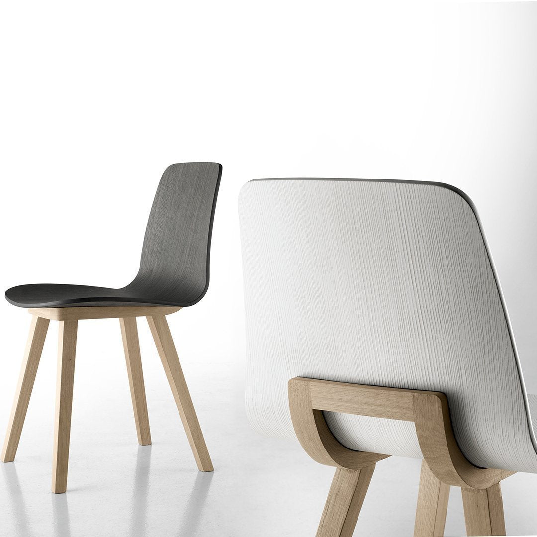 Modern chair featuring a sleek black seat and smooth white backrest, complemented by natural wood legs.