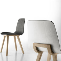Modern chair featuring a sleek black seat and smooth white backrest, complemented by natural wood legs.