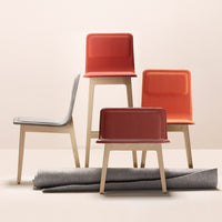Colorful modern chairs in orange, red, and gray, showcasing sleek designs and stylish patterns on minimalist display.