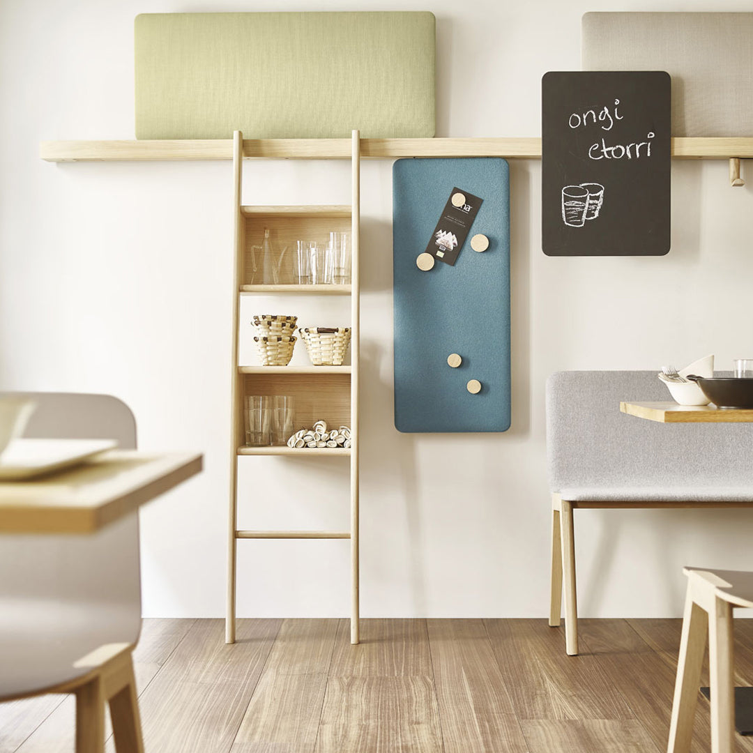 "Modern shelving unit with blue panel, green cushions, and neutral tones, featuring sleek wood and minimalistic design."