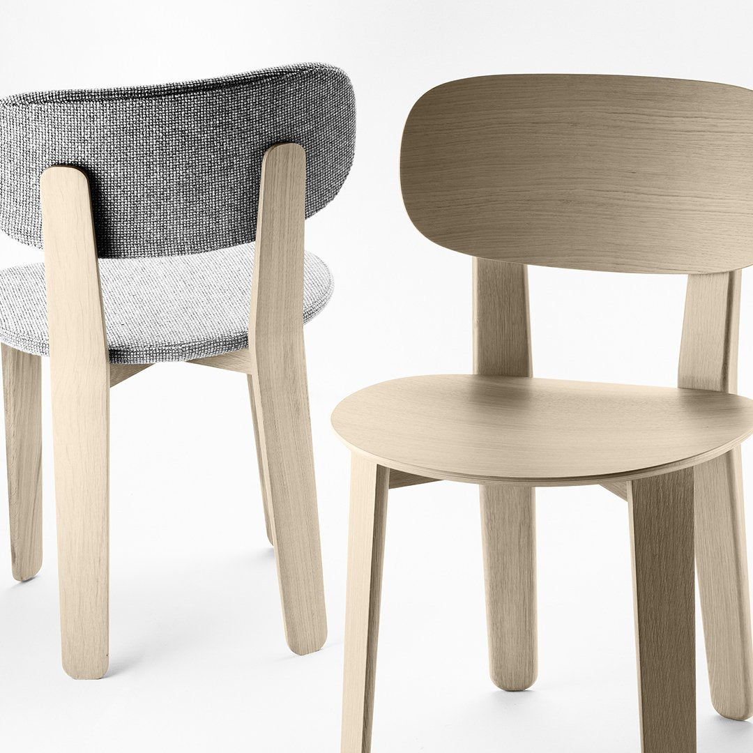 Two modern chairs featuring a light wood finish and a textured gray fabric backrest. Minimalist design and soft tones.