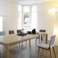 Modern dining room featuring a light wood table, grey and brown chairs, and a neutral color palette.