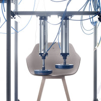 Minimalist beige chair with light wood legs, surrounded by blue cables against a bright background.