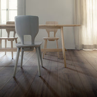 Light wood dining set featuring a gray chair, minimalist design, and warm wood flooring. Soft and neutral tones.