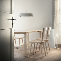 "Light wood dining table and chairs in a minimalist, neutral-toned space with soft natural lighting."