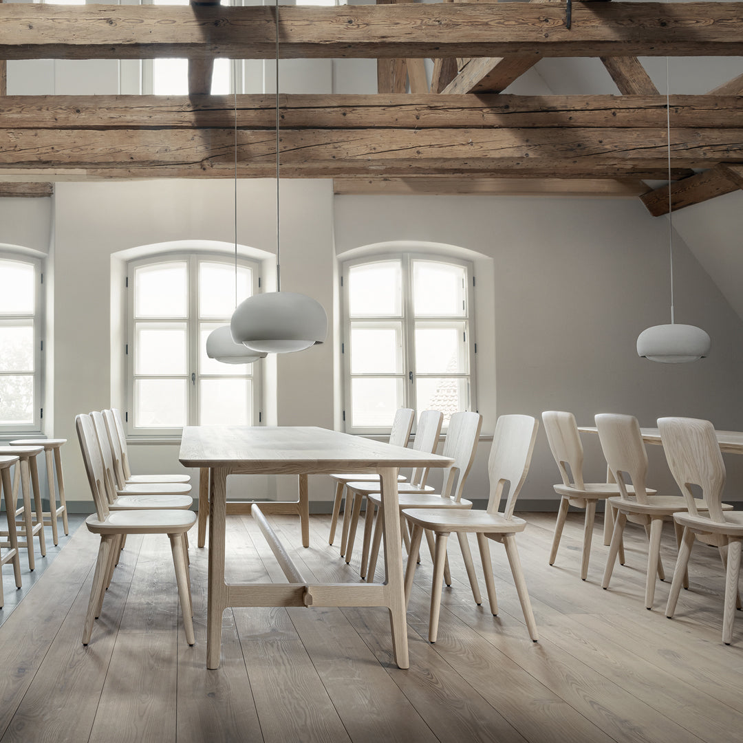 Light wooden furniture with soft gray accents and white walls, showcasing a minimalist and airy design.