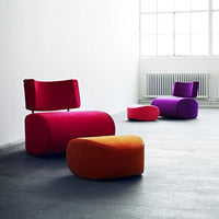 Vibrant pink, red, purple, and orange upholstered chairs and stools in a modern setting.