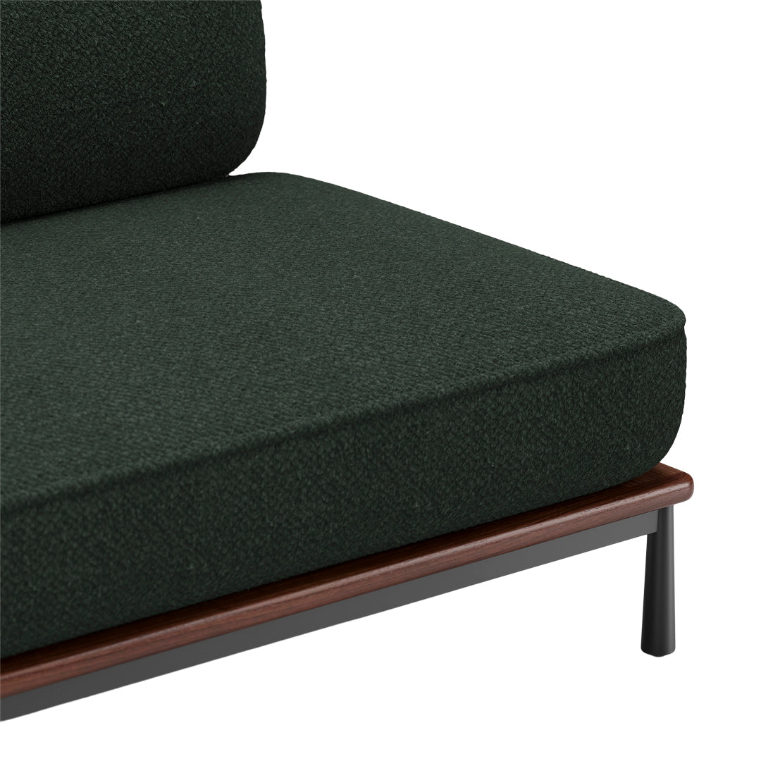 Dark green textured fabric sofa cushion with a wooden and metal frame detail.