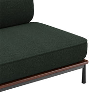 Dark green textured fabric sofa cushion with a wooden and metal frame detail.