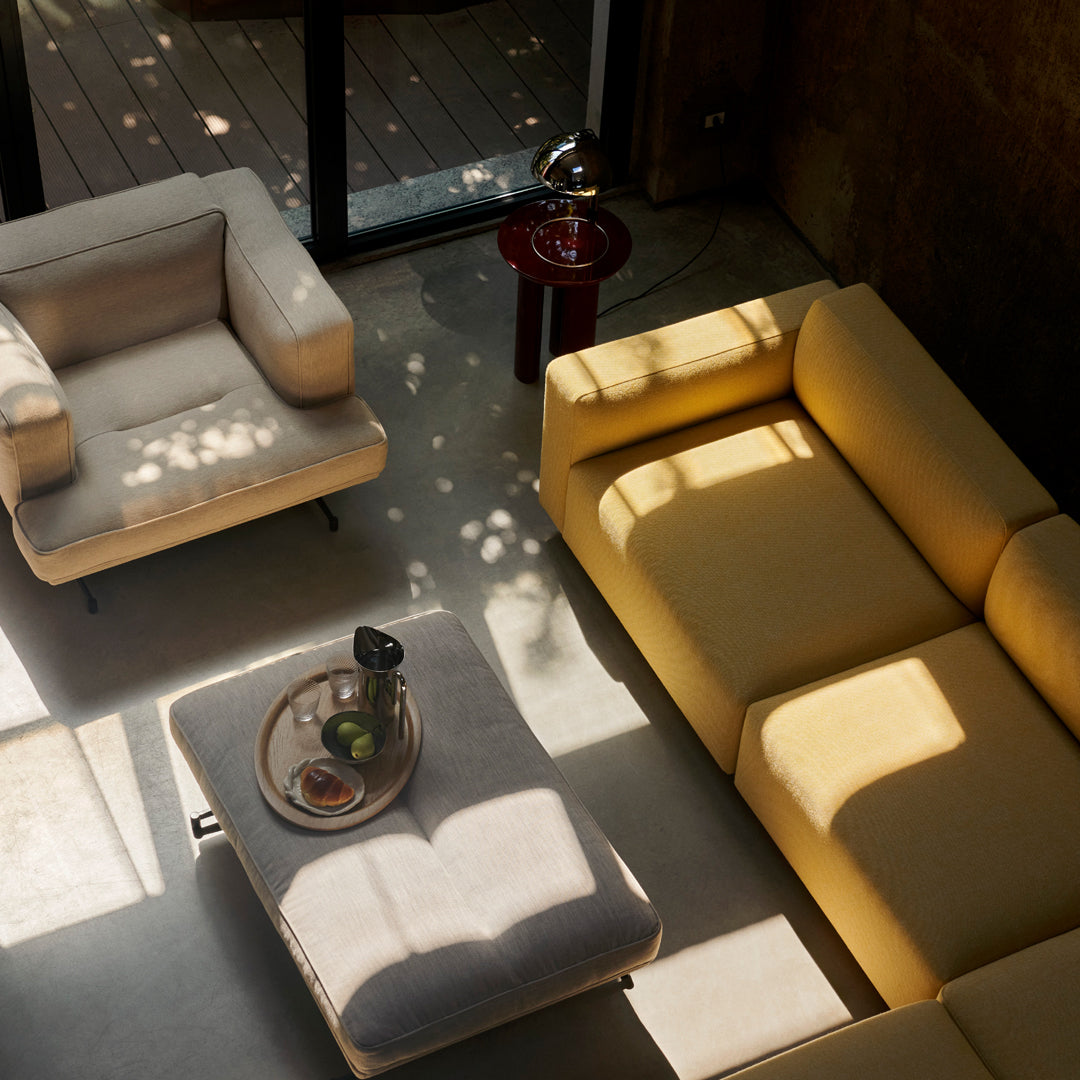 Stylish yellow and gray sofa with a cozy armchair, featuring soft textures and natural light patterns.