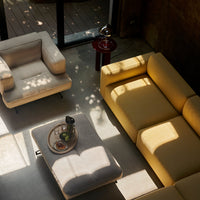 Stylish yellow and gray sofa with a cozy armchair, featuring soft textures and natural light patterns.