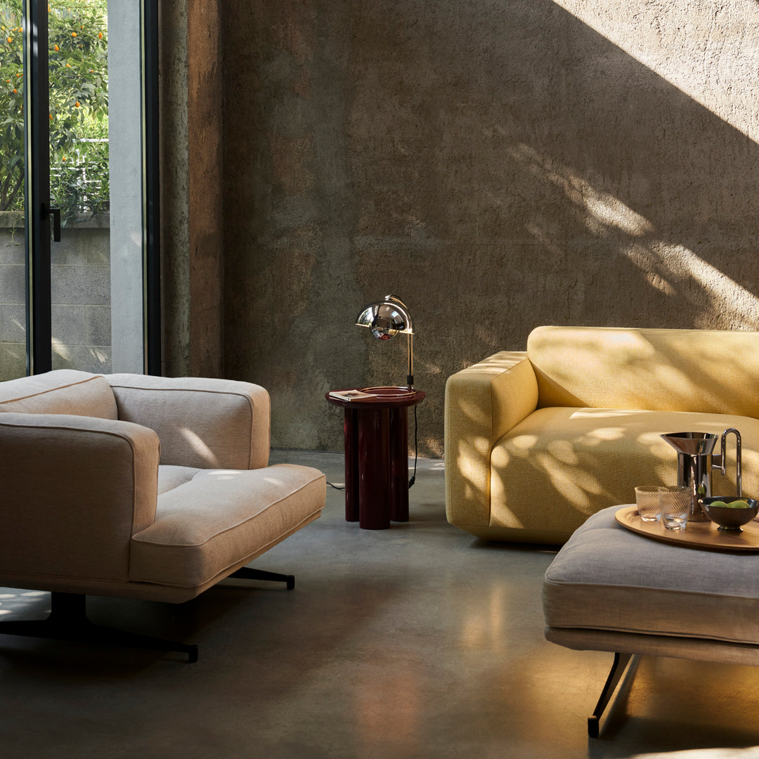Two modern sofas: one in soft beige, the other in vibrant yellow, against a textured gray wall. Warm, inviting tones.