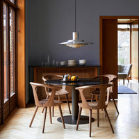 "Modern dining room featuring warm wood tones, sleek black table, and soft gray walls for a cozy ambiance."