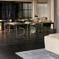 Modern office space featuring a muted color palette with green accents, black flooring, and soft gray textures.