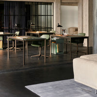 Modern workspace featuring dark flooring, green chairs, and neutral decor with clean lines and industrial accents.