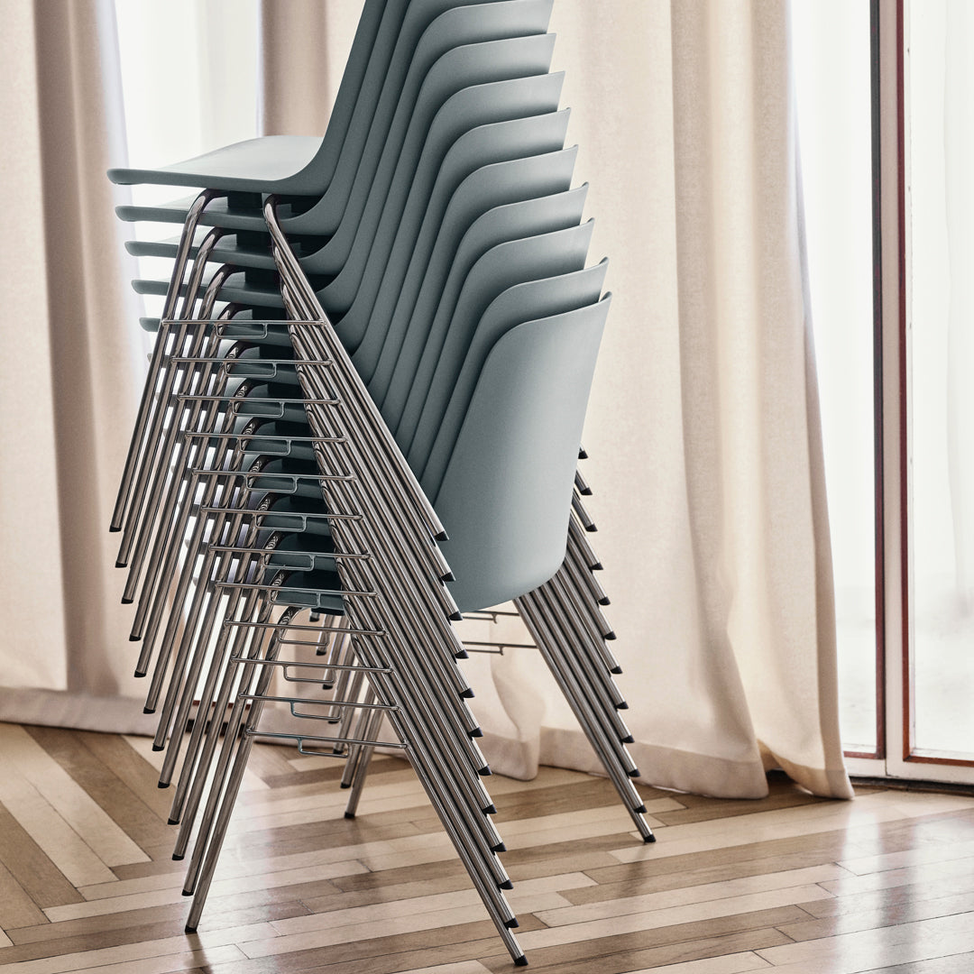 Stacked chairs in soft blue with sleek silver legs against a light, airy backdrop. Elegant design and minimalistic style.