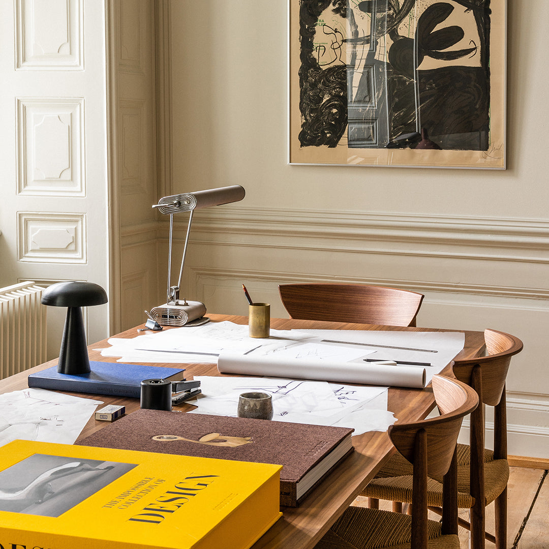 "Contemporary workspace featuring warm wood tones, sleek black accents, and vibrant yellow book cover against neutral walls."