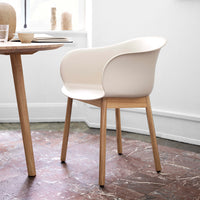 Modern beige chair with smooth curves and a natural wood base, set against a minimalist background.