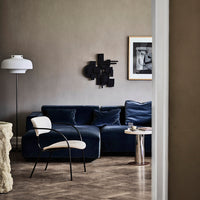 "Dark blue velvet sofa with neutral accents, paired with a black and white wall art and light wood flooring."