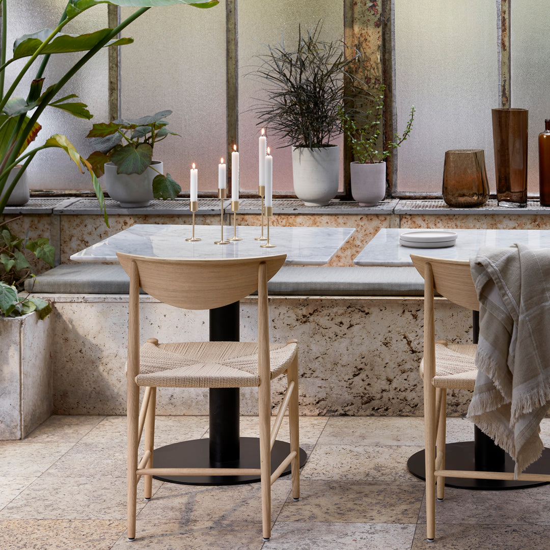 Minimalist dining set with natural wood tones, beige textures, and soft pastel accents in a serene indoor setting.