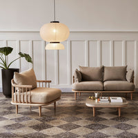 Beige upholstered sofa and chair with light wood accents, set against a patterned gray and beige tiled floor.