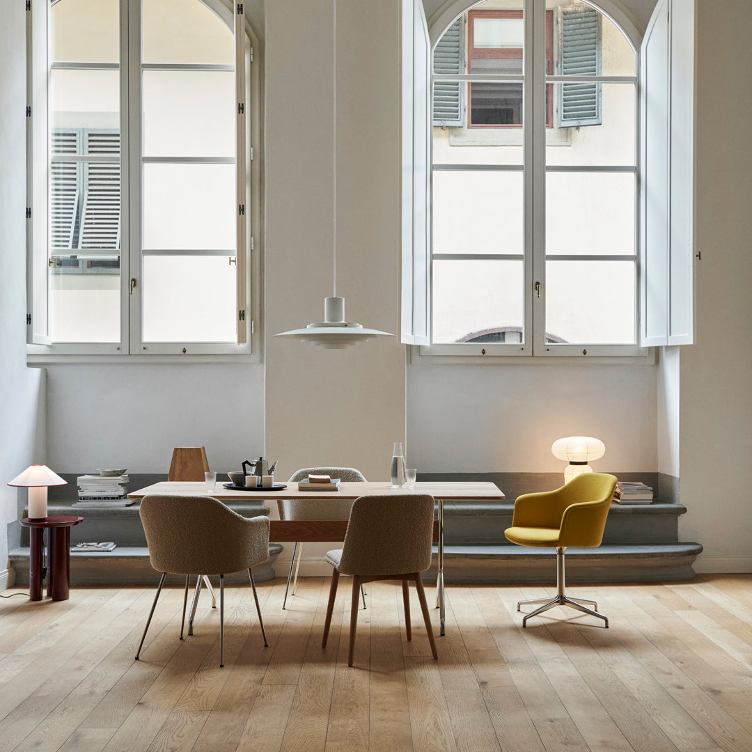 Modern workspace featuring beige chairs, a yellow accent chair, and natural wood flooring in a bright, airy room.